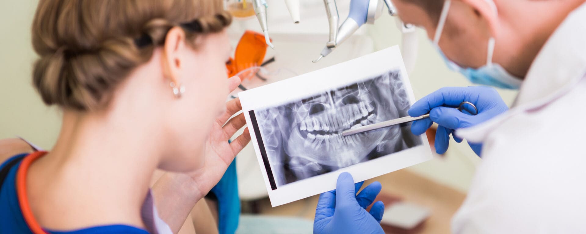 Dentist and patient looking at an X-ray of teeth.