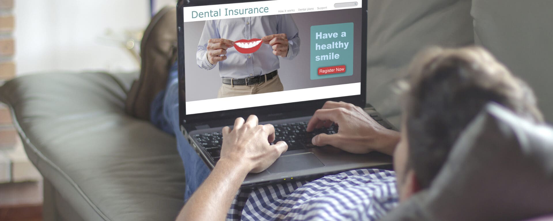 Man using laptop to research dental insurance.